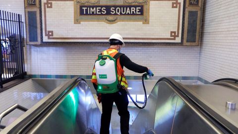 Un empleado desinfecta la estación de Times Square del metro de Nueva York durante la noche
