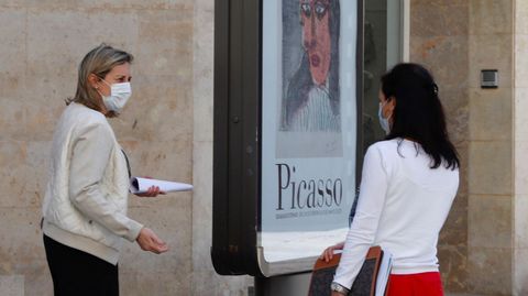 Dos mujeres con mascarilla conversan en una calle de Oviedo.
