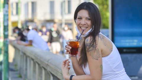 Una joven toma un aperitivo en la dársena de Milán