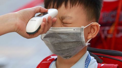 Un estudiante de primaria se somete a un control de temperatura el primer día de clase en Ho Chi Minh, Vietnam
