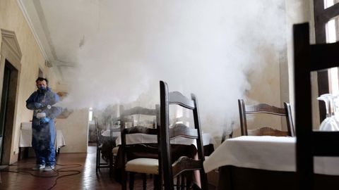 Un trabajador desinfecta el restaurante de Olimpo en Brescia, Italia