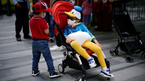 En Shanghai hoy ha reabierto el parque de atracciones de Disneyland. Lo usuarios acuden con mascarilla