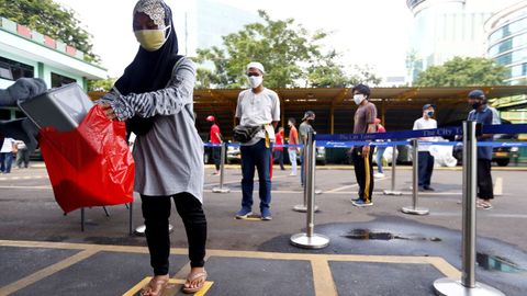 En Indonesia practican el distanciamiento social también cuando acuden a los dispensadores de arroz