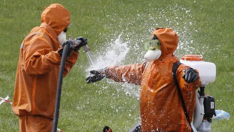 Personal de emergencias de San Petersburgo se rocía con desinfectante tras sofocar el incendio en un hospital con pacientes con coronavirus