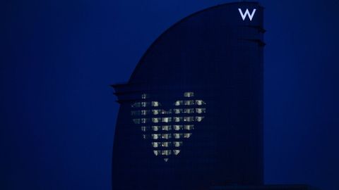 El hotel W de Barcelona, donde ha permanecido confinado durante dos meses su director de mantenimiento, ilumina cada noche su fachada con un mosaico en forma de corazón gracias a la luz que sale de diversas habitaciones. Es una especie de mensaje de ánimo a la población durante el vigente estado de alarma