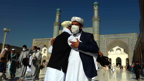 Dos afganos se saludan, hoy domingo, al celebrar el fin del Ramadn, en la ciudad de Herat