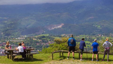 Varias personas contemplan Oviedo este domingo en la cumbre del monte Naranco