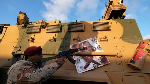 Un combatiente de las fuerzas de Haftar apunta a una imagen de Erdogan colgada de un blindado turco confiscado durante los combates en Trípoli 