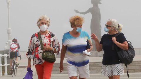 El Muro de de Gijón, con la playa de San Lorenzo cubierta de niebla