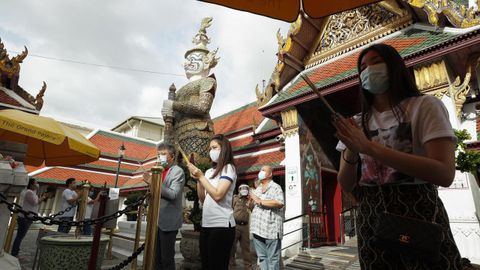 Devotos oran en un templo de Bangkok