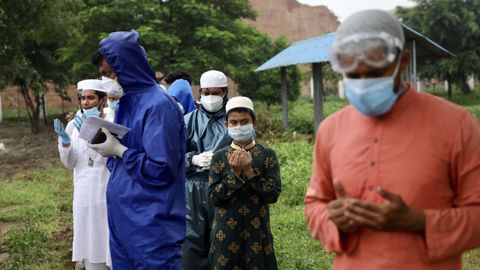 Familiares oran durante el entierro de un fallecido por covid-19 en Bangladesh