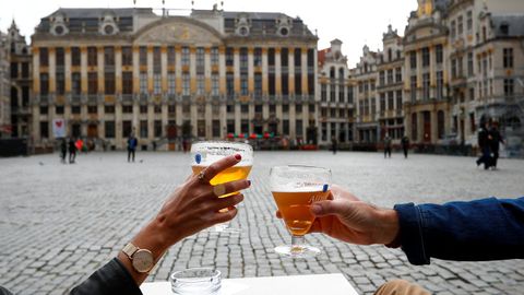 En Bélgica han reabierto bares y restaurantes. Una pareja brinda en la Gran Plaza de Bruselas