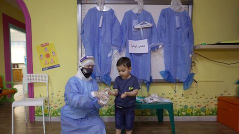 En Jordania, una profesora enseña a un alumno cómo utilizar los productos desinfectantes