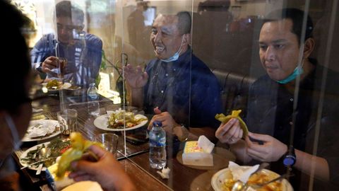 Las mamparas plásticas separadoras se han convertido en habituales en los restaurantes de Jakarta