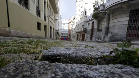 Entre los adoquines crece la hierba y los baches están presentes en varias zonas de la calzada