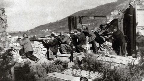 Voluntarios y guardias civiles defienden la posicin de San Pedro de los Arcos de Oviedo durante la Guerra Civil. El cementerio, desde donde disparan, qued parcialmente destruido durante los combates