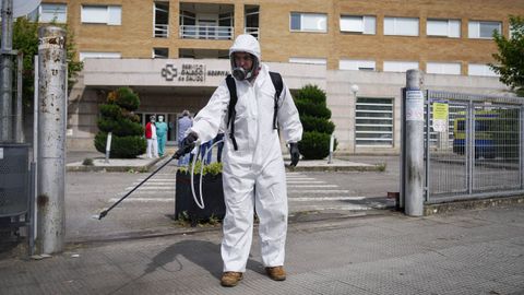 Un operario desinfecta la entrada del hospital de Verín