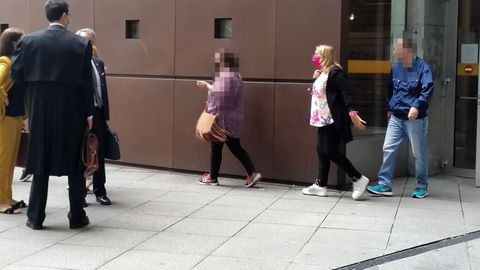  La madre condenada por quedarse con dinero de su hijo, con mascarilla rosa, a la salida de la Audiencia