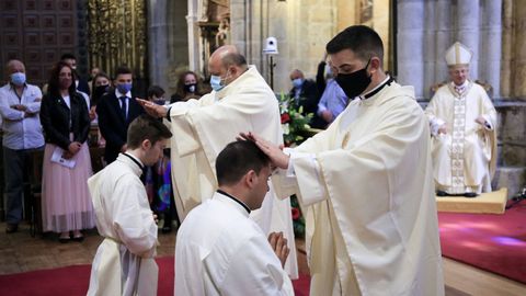 El obispo en primer lugar, y luego el resto de sacerdotes, imponen las manos sobre los candidatos.