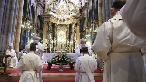El obispo en primer lugar, y luego el resto de sacerdotes, imponen las manos sobre los candidatos.