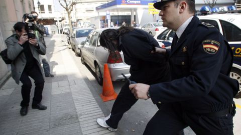 Momento en que uno de los detenidos entra en el juzgado custodiado por la policía el 24 de marzo del 2009