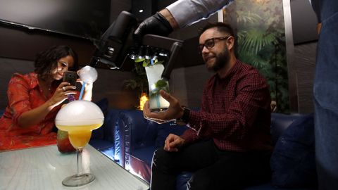 Dos jóvenes fotografían el efecto de una Flavour Blaster sobre su cóctel en el pub Alquimia, en Lugo
