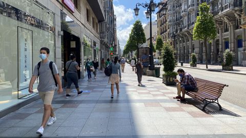 Varios transeúntes por la calle Uría de Oviedo, con la mascarilla puesta