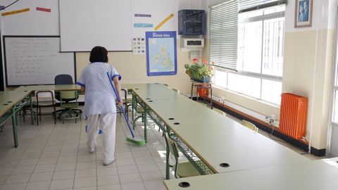 Personal de limpieza trabajando en un aula de un colegio público en una foto de archivo