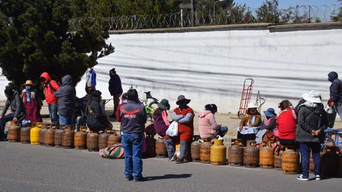 Varias personas esperan en fila para recargar cilindros de gas frente a una planta productora, en El Alto, Bolivia