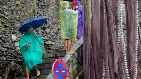  Un grupo de turistas visita Cudillero, bajo una intensa lluvia