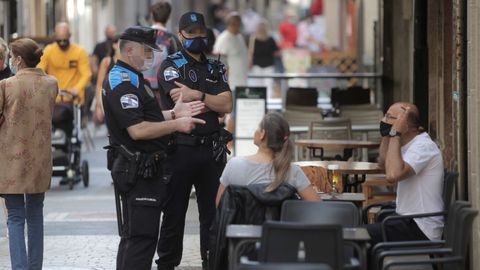 Dos agentes de la policía local de A Coruña patrullan por una céntrica calle de la ciudad. Imagen de archivo