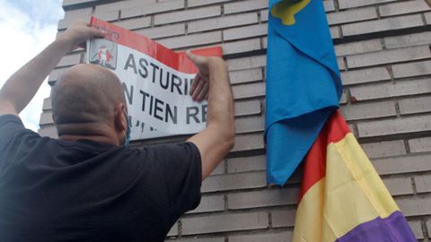 Un manifestante tapa el nombre de Juan Carlos Primero en la avenida homnima con una pegatina con la leyenda Asturies nun tien rey, en Gijn