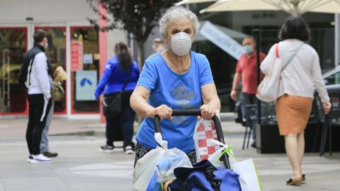 Una mujer de compras en el barrio de A Milagrosa, uno de los más populosos de Lugo y que está sometido a restricciones por la transmisión del coronavirus