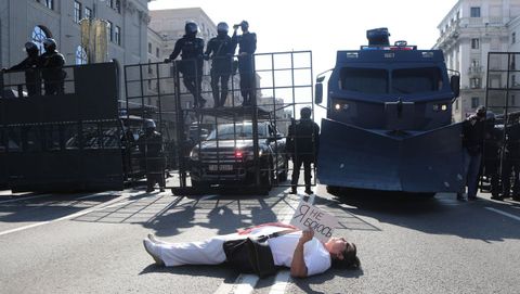 Una mujer yace en el suelo y sostiene el cartel «No tengo miedo» frente a la policía durante la manifestación del domingo en Minsk