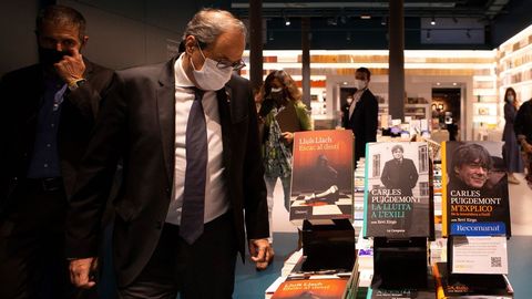 Quim Torra, este jueves, observa los libros publicados por el cantante Lluís Llach y por el prófugo de la Justicia Carles Puigdemont
