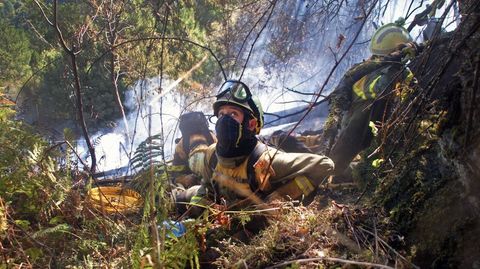Integrantes de la brigada contraincendios de Quiroga se preparan para la descarga de un hidroavión que pasa sobre ellos