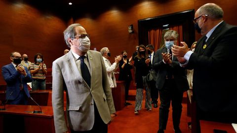 Quim Torra es aplaudido por sus compañeros a su llegada hoy a la reunión que ha mantenido el grupo parlamentario de JxCat en el Parlament