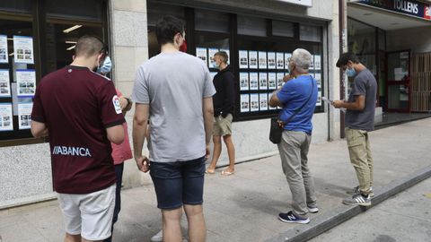 Distintos clientes hacen cola en una inmobiliaria en una imagen de julio