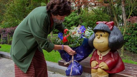 Una mujer pone unas flores junto a la imagen de Mafalda hoy miércoles en el campo San Francisco de Oviedo. EFE.
