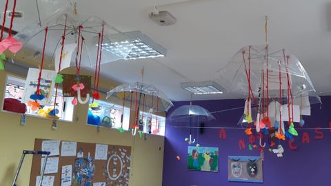 En el CRA Nosa Señora do Faro, en Ponteceso, se ha retirado toda la decoración del aula y solo han quedado unos paraguas colgados del techo donde se exponen los trabajos de cada alumno. Decorados con flores de papel y tiras de lana, con las ventanas abiertas (para airear) las piezas se mueven, dando lugar a juegos para los niños