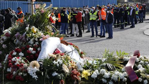 Coronas de flores, ayer, en la entrada de la fábrica, donde el personal continúa protestando