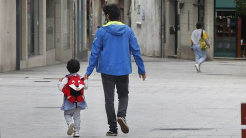 Imagen de archivo de un niño caminando con su padre tras salir del colegio