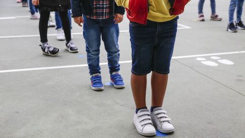 Imagen de archivo de escolares guardando la distancia de seguridad para entrar al colegio