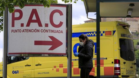 Una mujer con mascarilla frente a la entrada de urgencias del hospital de Monforte
