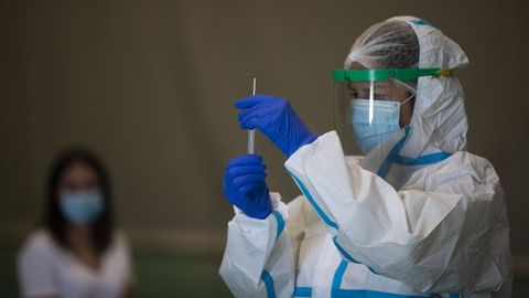 Una sanitaria atiende a una mujer durante las pruebas de cribado de covid-19 con test de antígenos en Sevilla