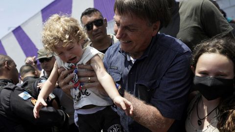 Bolsonaro levanta a un niño tras votar el domingo en Rio de Janeiro