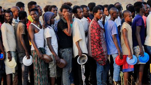 Refugiados etíopes huidos de Tigray hacen cola para conseguir comida en un campamento en la frontera con Sudan