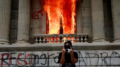 Varios manifestantes ante el Congreso de Guatemala, en llamas