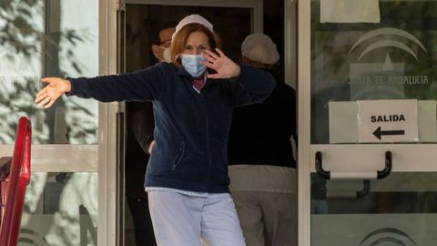 Una cuidadora del Centro para Personas Mayores de Heliópolis en Sevilla bailando al son de la música de la megafonía mientras espera hoy en la puerta de esta residencia pública la llegada de las dosis