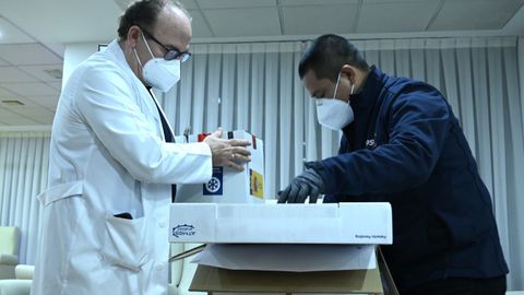 Un operario da a un médico de la residencia la vacuna contra la Covid-19 durante el primer día de vacunación, en la residencia de mayores Los Olmos de Guadalajara